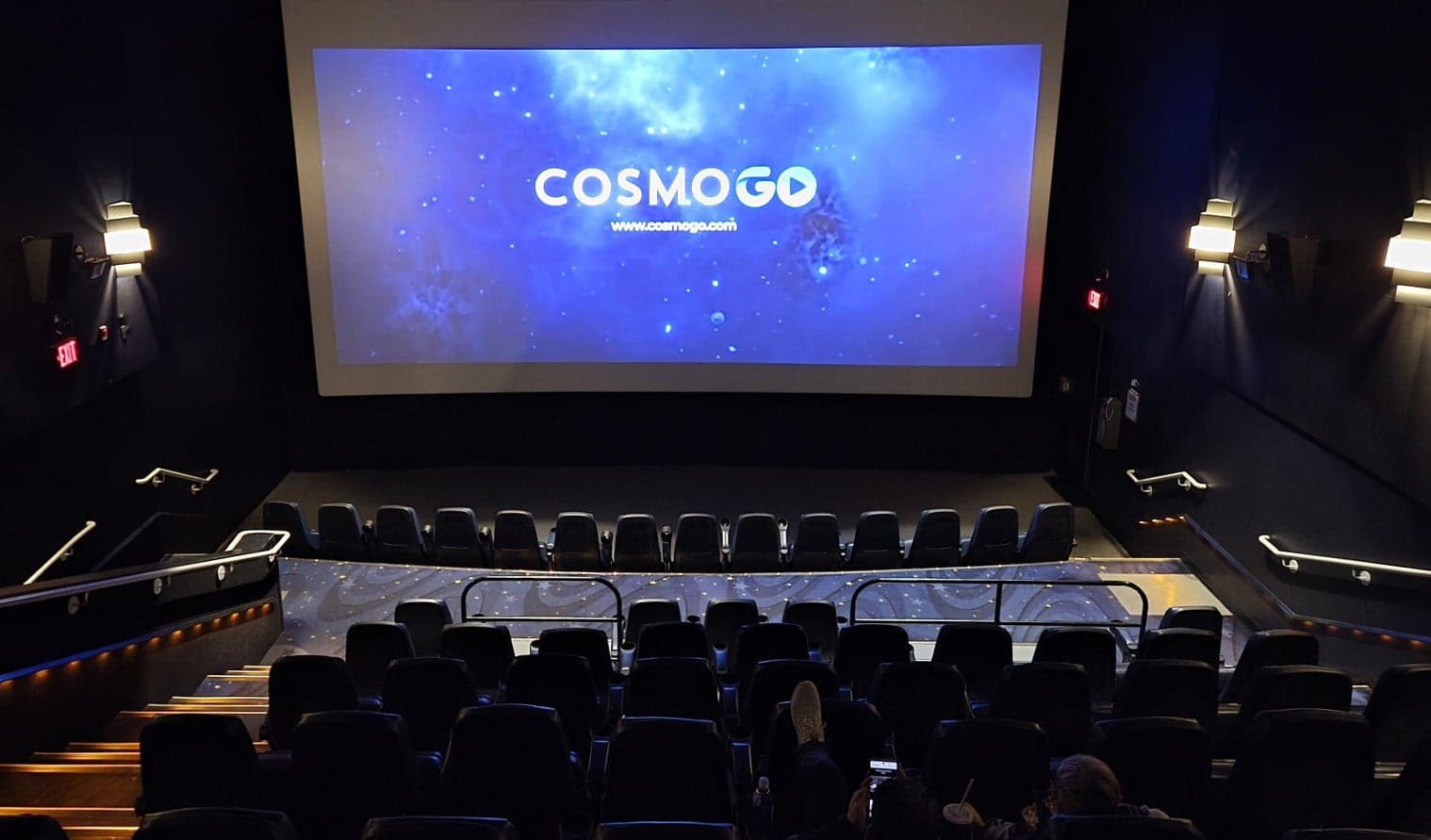 Audience in a Cineplex theatre viewing a CosmoGo advertisement on the big screen