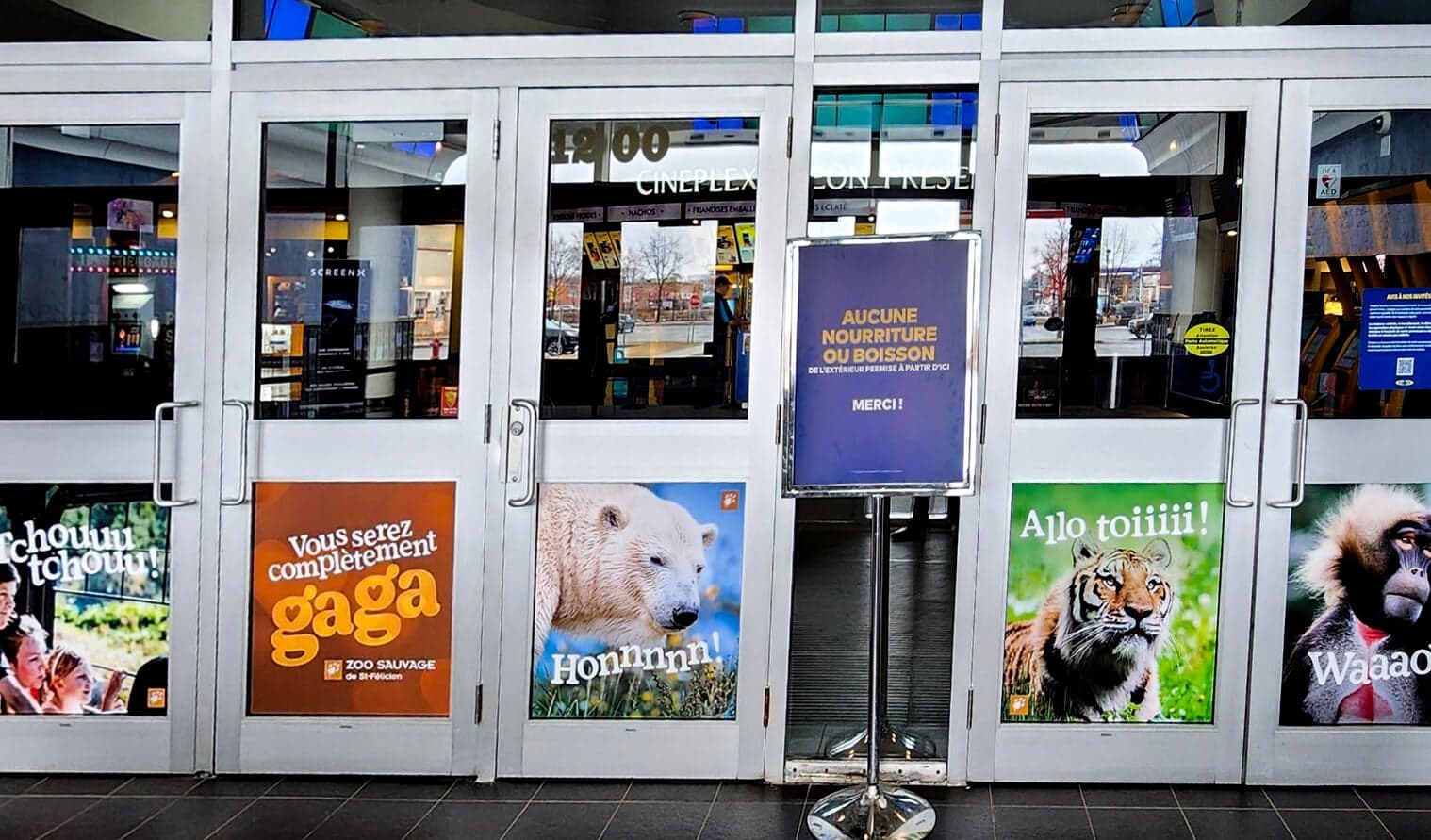 Entrance doors of Cineplex Odeon Ste-Foy decorated with Zoo Sauvage animal-themed advertisements