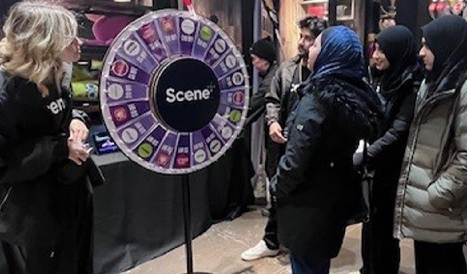 Group of people participating in a SCENE rewards prize wheel activation at The Rec Room