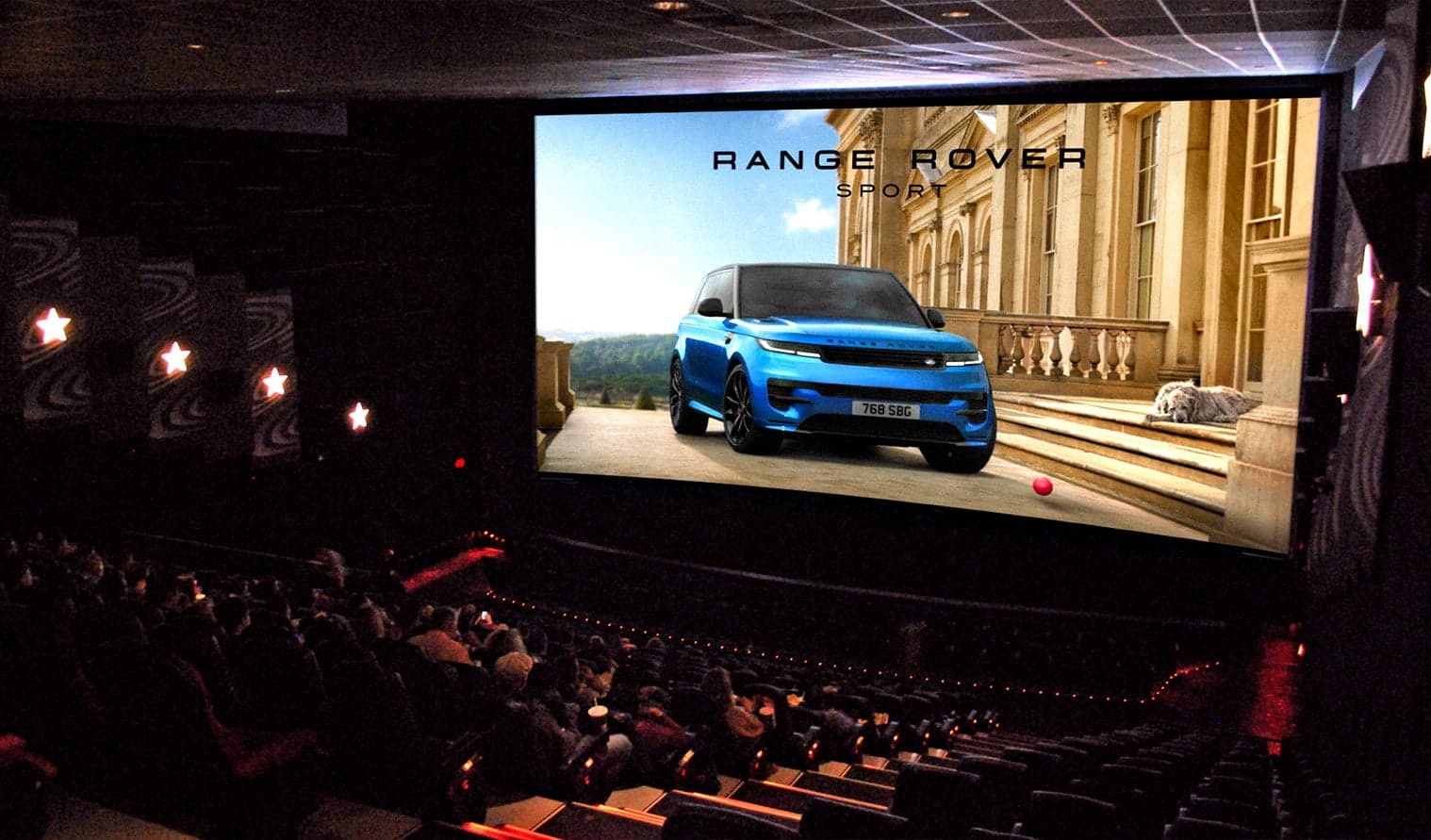 Audience watching a Range Rover advertisement on a large screen in a Cineplex theatre