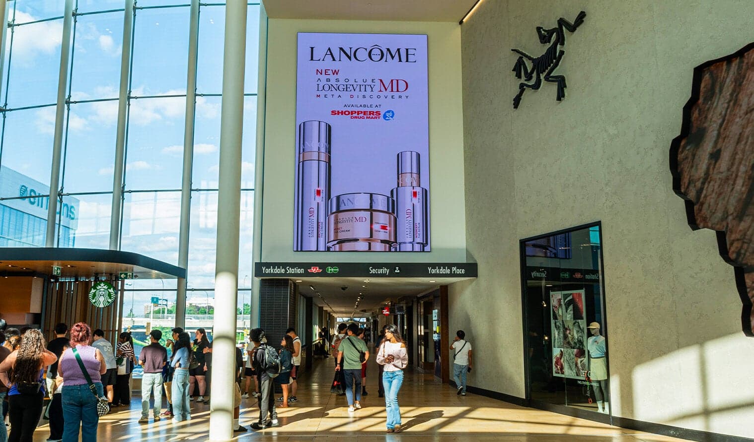 Tall digital screen in Yorkdale mall displaying Lancôme advertisement for skincare products